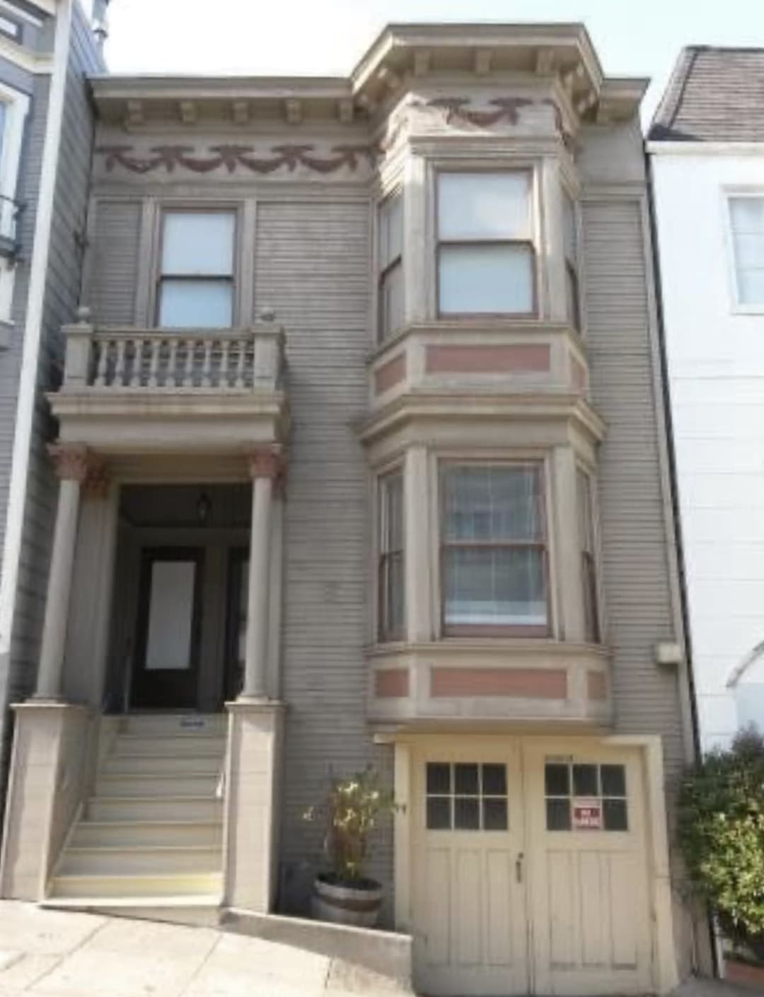 Before picture of an unfinished victorian home in need of a paint job